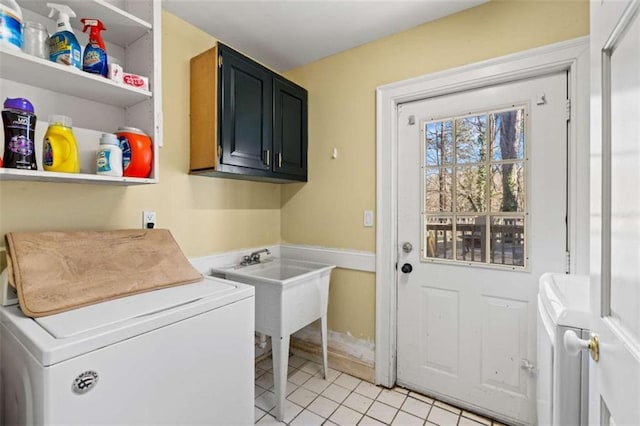 laundry room with washer and clothes dryer, light tile patterned flooring, and cabinets