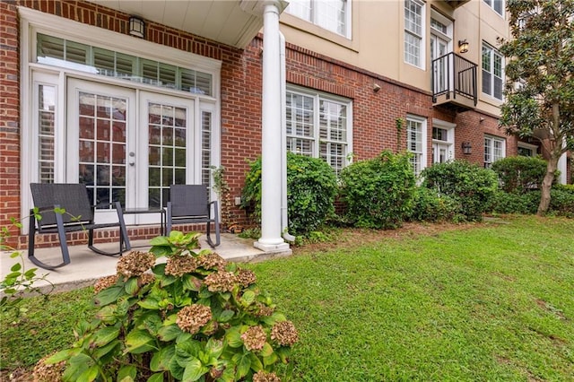 entrance to property featuring a lawn and french doors