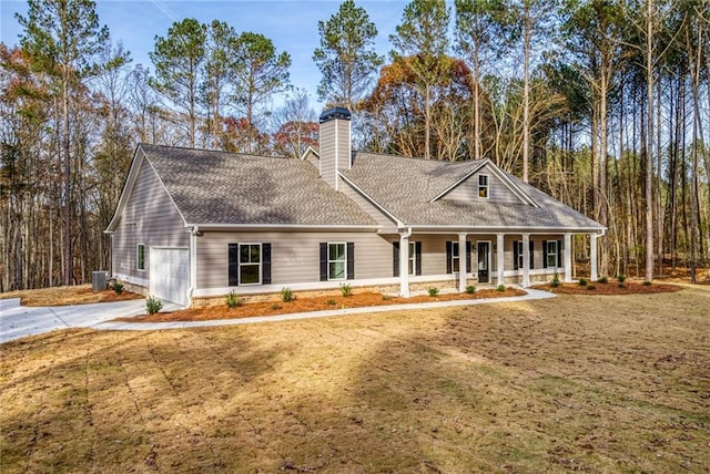 view of front of home with covered porch, a front lawn, an attached garage, and central air condition unit