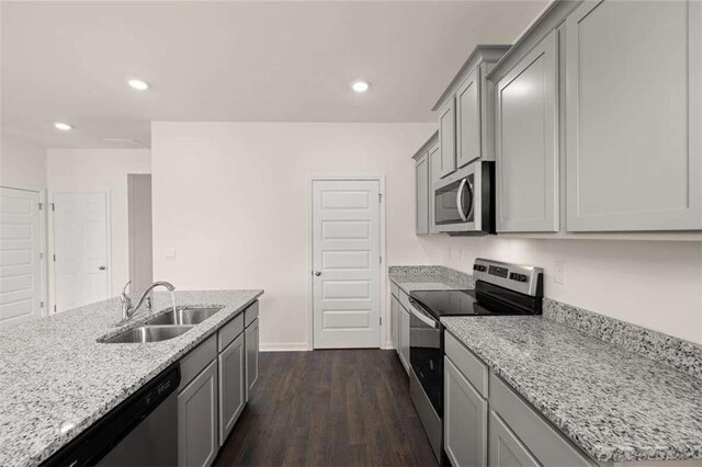 kitchen featuring dark wood finished floors, gray cabinets, appliances with stainless steel finishes, and a sink