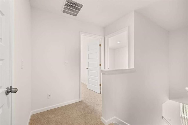 hallway with visible vents, baseboards, and carpet flooring