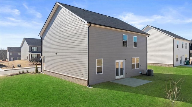 rear view of house featuring a yard and central air condition unit