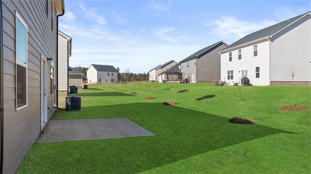 view of yard with central AC unit and a residential view