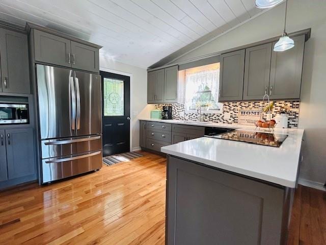 1008 Lakeview Acres, Hiawassee, GA 30546 - kitchen featuring stainless steel appliances, vaulted ceiling, gray cabinetry, tasteful backsplash, and light wood-type flooring