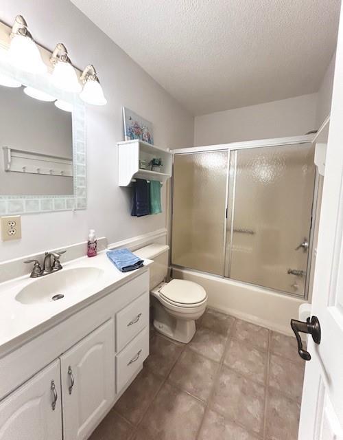 1008 Lakeview Acres, Hiawassee, GA 30546 - full bathroom featuring vanity, a textured ceiling, toilet, enclosed tub / shower combo, and tile patterned flooring