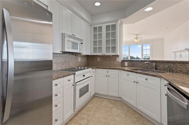 4100 Paces Walk SE Unit 4306, Atlanta, GA 30339 - kitchen with stainless steel appliances, a sink, decorative backsplash, dark stone countertops, and recessed lighting