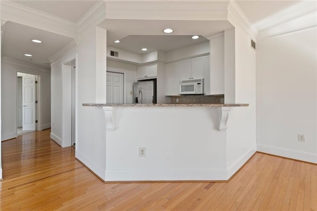 4100 Paces Walk SE Unit 4306, Atlanta, GA 30339 - kitchen with stainless steel fridge, white microwave, light wood-type flooring, light stone countertops, and crown molding