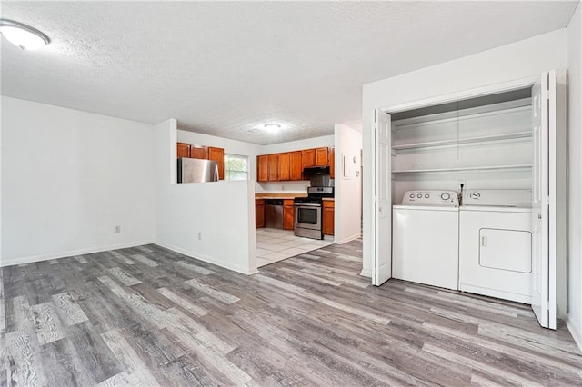 3799 Henry Ct, Acworth, GA 30101 - kitchen featuring stainless steel appliances, separate washer and dryer, light wood-style flooring, a textured ceiling, and brown cabinetry