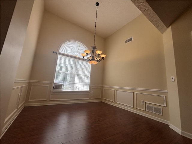 2840 Alcovy River Vw, Dacula, GA 30019 - unfurnished room with lofted ceiling, wood-type flooring, a chandelier, a wainscoted wall, and a decorative wall