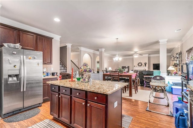 kitchen with stainless steel fridge with ice dispenser, open floor plan, ornate columns, and light wood-type flooring