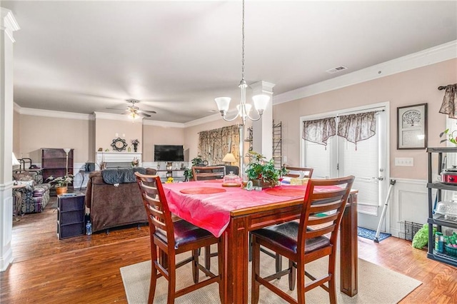 dining room featuring ceiling fan with notable chandelier, wood finished floors, visible vents, and ornamental molding