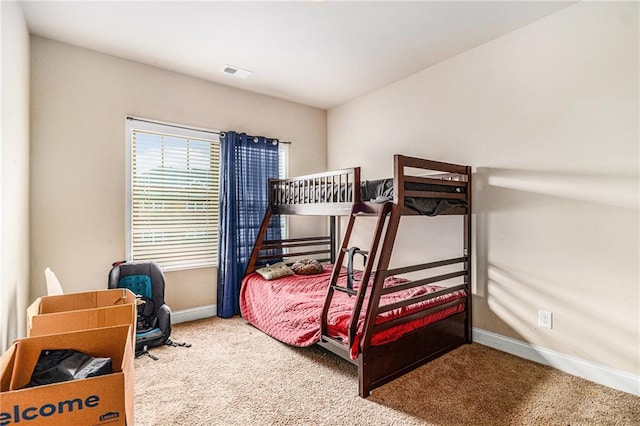 carpeted bedroom featuring visible vents and baseboards