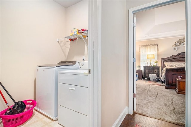 clothes washing area featuring washer and dryer, baseboards, and laundry area