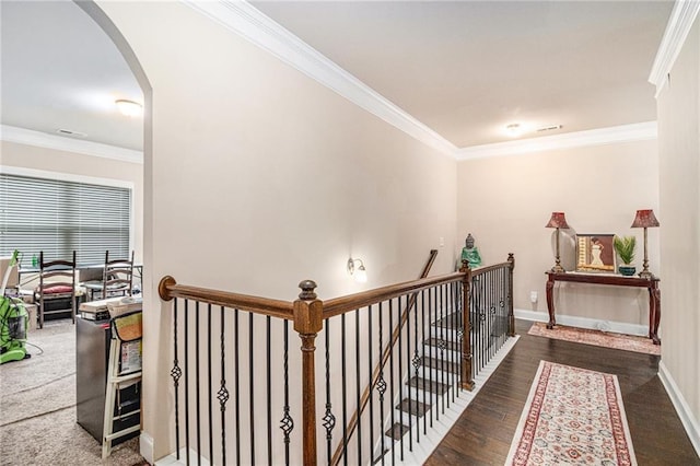 corridor with baseboards, an upstairs landing, arched walkways, and ornamental molding