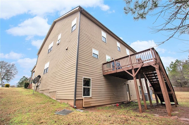 rear view of house featuring a yard, a deck, and stairs