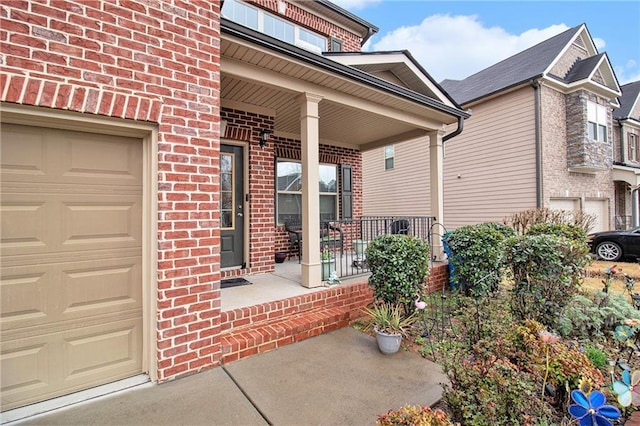 doorway to property with a porch, an attached garage, and brick siding