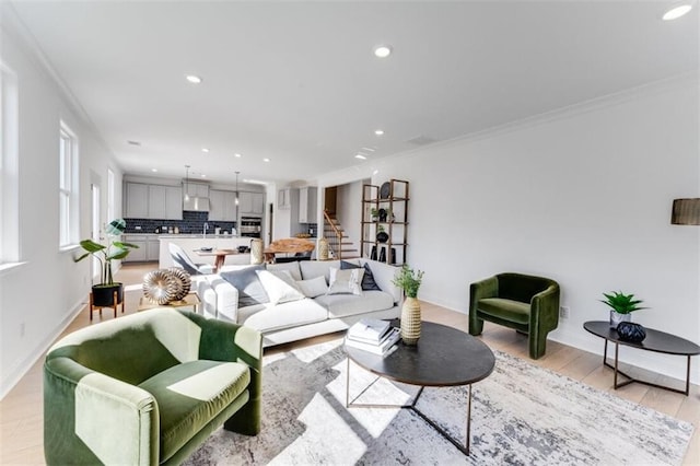 living area with recessed lighting, light wood-style flooring, and ornamental molding