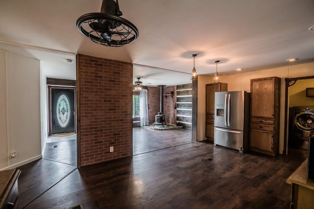 1530 Unity Church Cir, Maysville, GA 30558 - kitchen featuring washer / clothes dryer, stainless steel fridge, a wood stove, brick wall, and dark wood finished floors