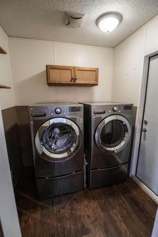 1530 Unity Church Cir, Maysville, GA 30558 - laundry room with cabinet space, washer and clothes dryer, dark wood-style flooring, and a textured ceiling