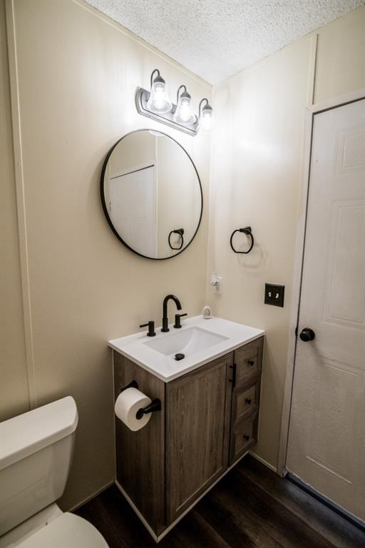 1530 Unity Church Cir, Maysville, GA 30558 - half bathroom featuring vanity, wood finished floors, and a textured ceiling