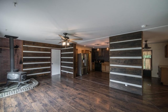 1530 Unity Church Cir, Maysville, GA 30558 - unfurnished living room with a wood stove, a ceiling fan, dark wood-style floors, and wooden walls