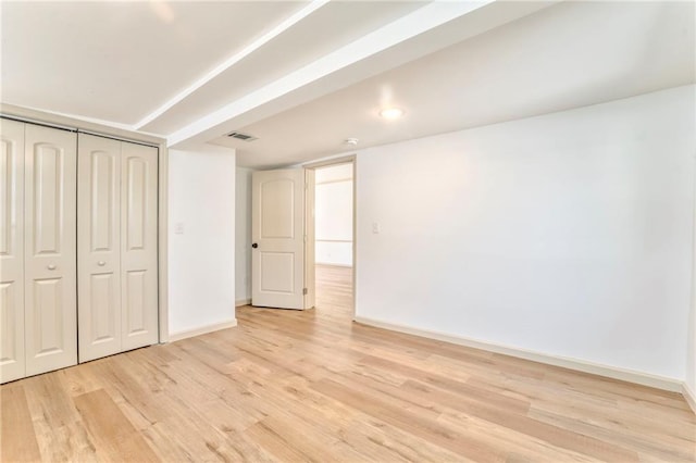 interior space featuring visible vents, light wood-style floors, and baseboards