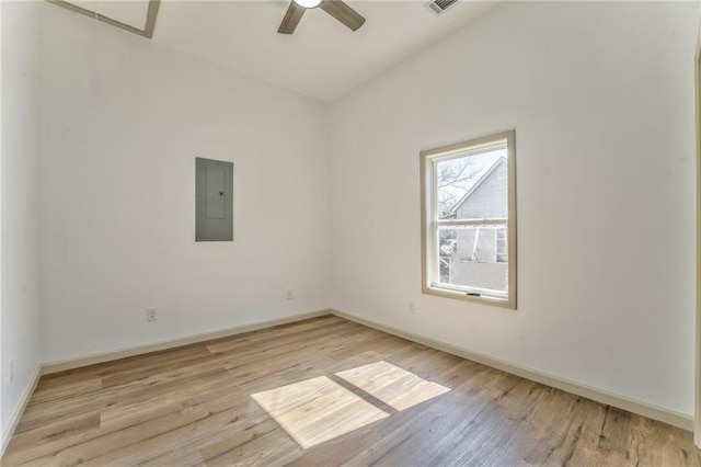 unfurnished room with a ceiling fan, electric panel, light wood-style floors, and baseboards