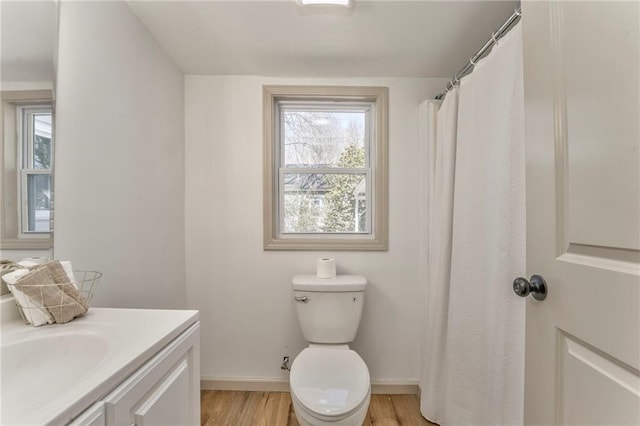 full bath featuring plenty of natural light, toilet, wood finished floors, and vanity