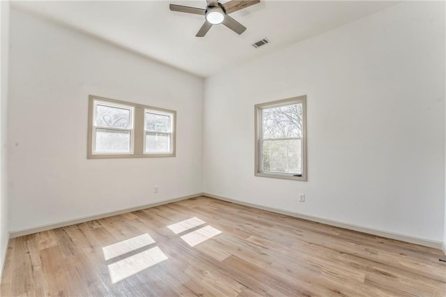 spare room with a ceiling fan, baseboards, visible vents, and light wood finished floors