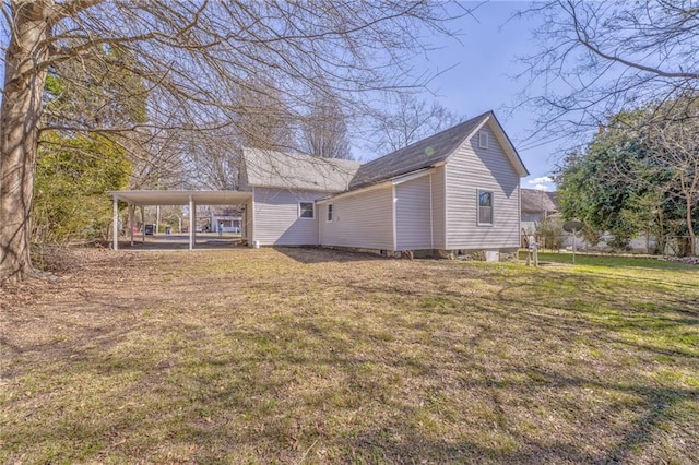 back of property featuring a yard and an attached carport