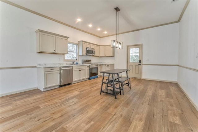 kitchen featuring a sink, stainless steel appliances, baseboards, and light wood-style floors