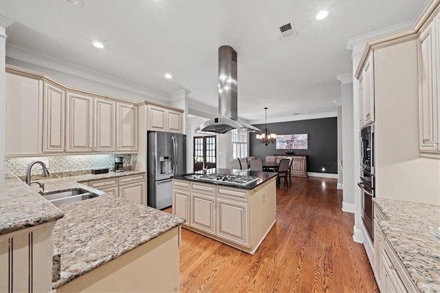 1323 Frey Lake Ct, Kennesaw, GA 30144 - kitchen featuring island exhaust hood, cream cabinetry, a sink, appliances with stainless steel finishes, and crown molding