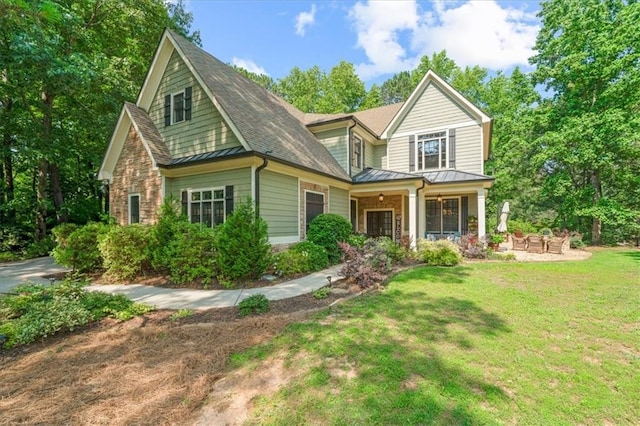 1323 Frey Lake Ct, Kennesaw, GA 30144 - view of front facade featuring a standing seam roof, a front yard, stone siding, and metal roof