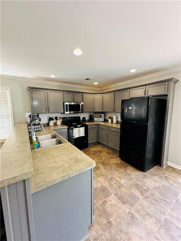 kitchen featuring black appliances, sink, gray cabinets, ornamental molding, and kitchen peninsula