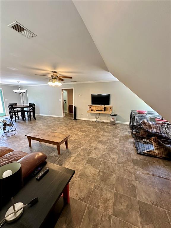 living room featuring ceiling fan with notable chandelier