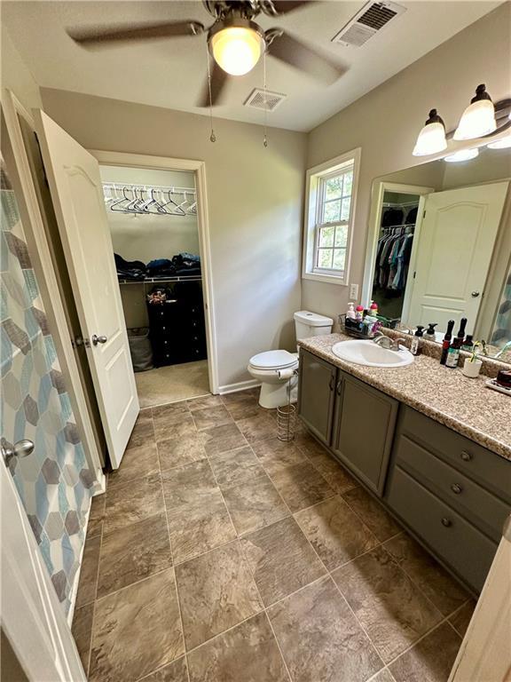 bathroom with vanity, toilet, and ceiling fan