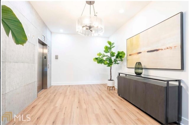 hall with elevator and light hardwood / wood-style flooring