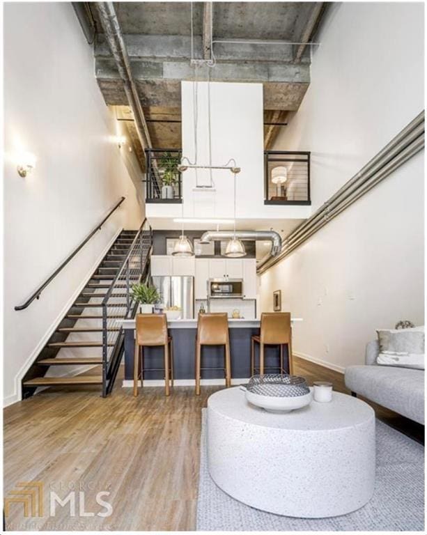 living room featuring wood-type flooring and a high ceiling