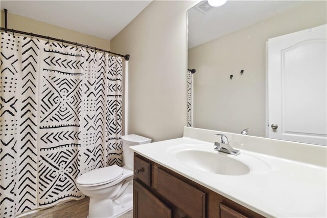 full bathroom featuring a shower with shower curtain, toilet, wood finished floors, and vanity