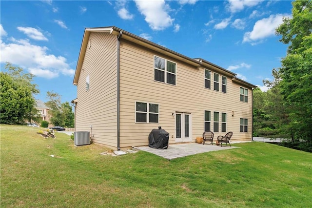 back of property with a yard, a patio area, and central AC