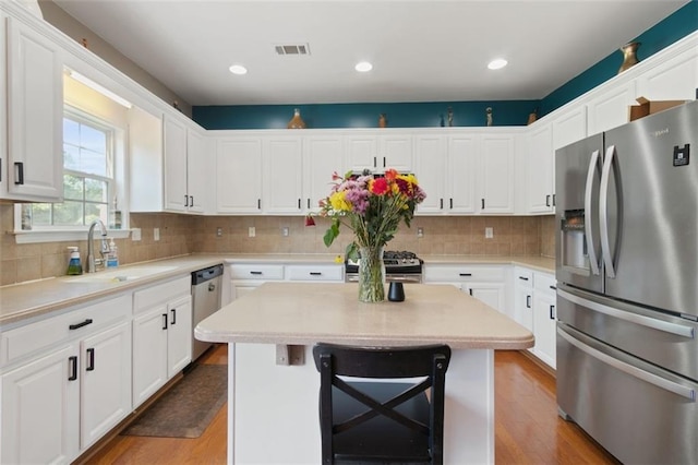 829 Castlebottom Dr, Lawrenceville, GA 30045 - kitchen featuring appliances with stainless steel finishes, a sink, a kitchen island, white cabinetry, and recessed lighting