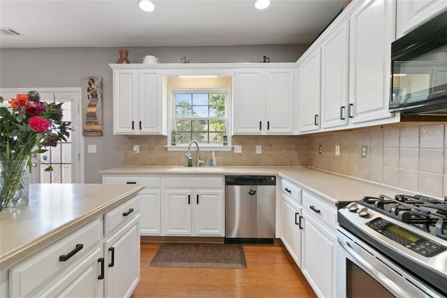 829 Castlebottom Dr, Lawrenceville, GA 30045 - kitchen featuring appliances with stainless steel finishes, a sink, light countertops, white cabinets, and light wood finished floors