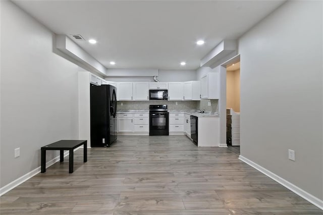 829 Castlebottom Dr, Lawrenceville, GA 30045 - kitchen featuring black appliances, light countertops, decorative backsplash, white cabinets, and light wood-style flooring