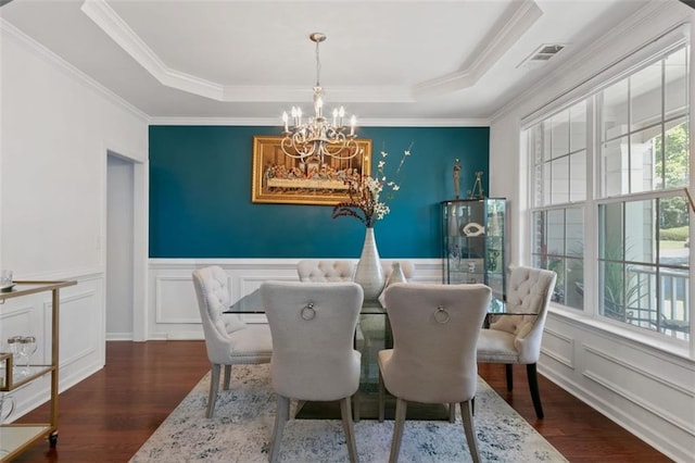 829 Castlebottom Dr, Lawrenceville, GA 30045 - dining room featuring a chandelier, wood finished floors, a decorative wall, a raised ceiling, and ornamental molding