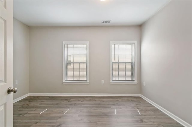 829 Castlebottom Dr, Lawrenceville, GA 30045 - empty room featuring healthy amount of natural light, wood finished floors, and baseboards