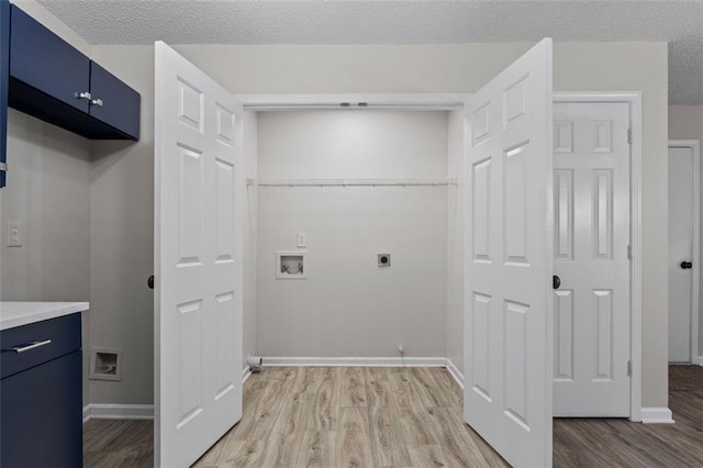 laundry area with cabinets, hookup for a washing machine, light wood-type flooring, and hookup for an electric dryer