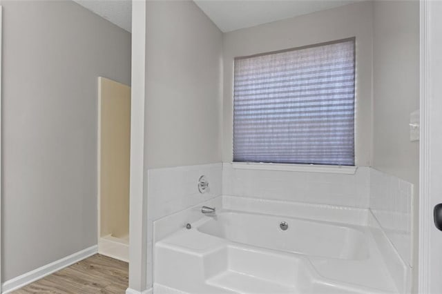 bathroom featuring wood-type flooring and a bathing tub