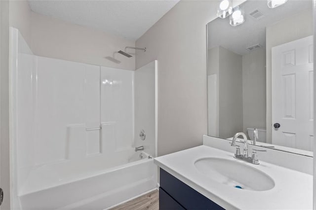 full bathroom with shower / bathing tub combination, vanity, hardwood / wood-style flooring, and toilet