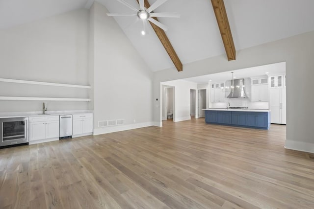 unfurnished living room featuring high vaulted ceiling, light wood-style flooring, wine cooler, and visible vents