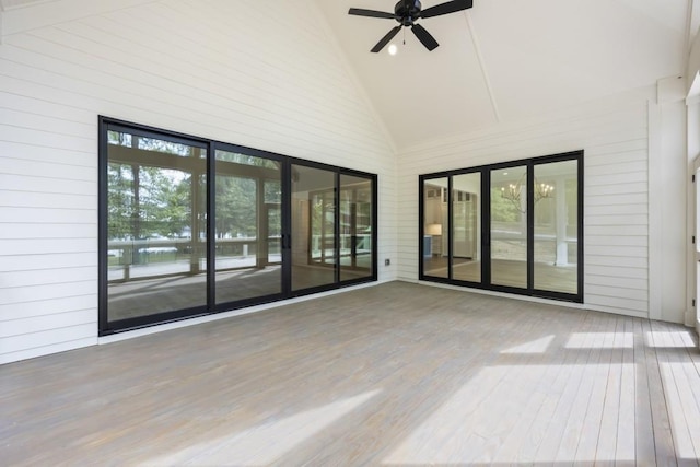 unfurnished sunroom with ceiling fan, plenty of natural light, and vaulted ceiling